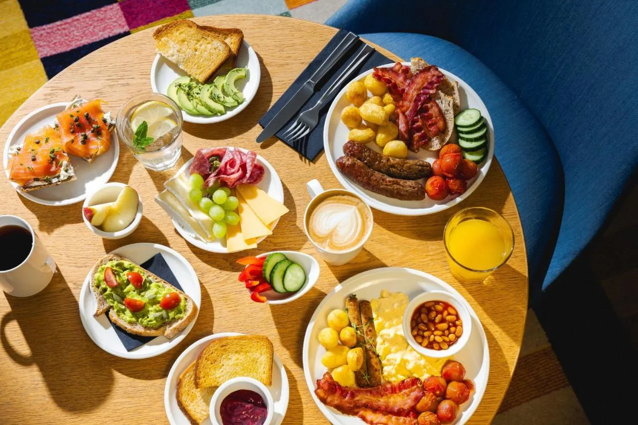 a wooden table with plates of food on it at citizenM Glasgow in Glasgow